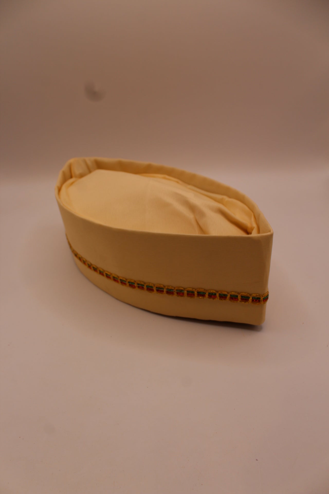Cream Gandhi topi with gold braid trim, top view