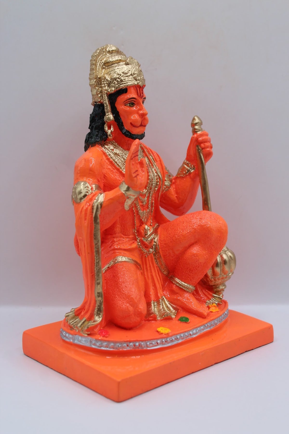 Orange resin Hanuman murti kneeling with gada, left side view