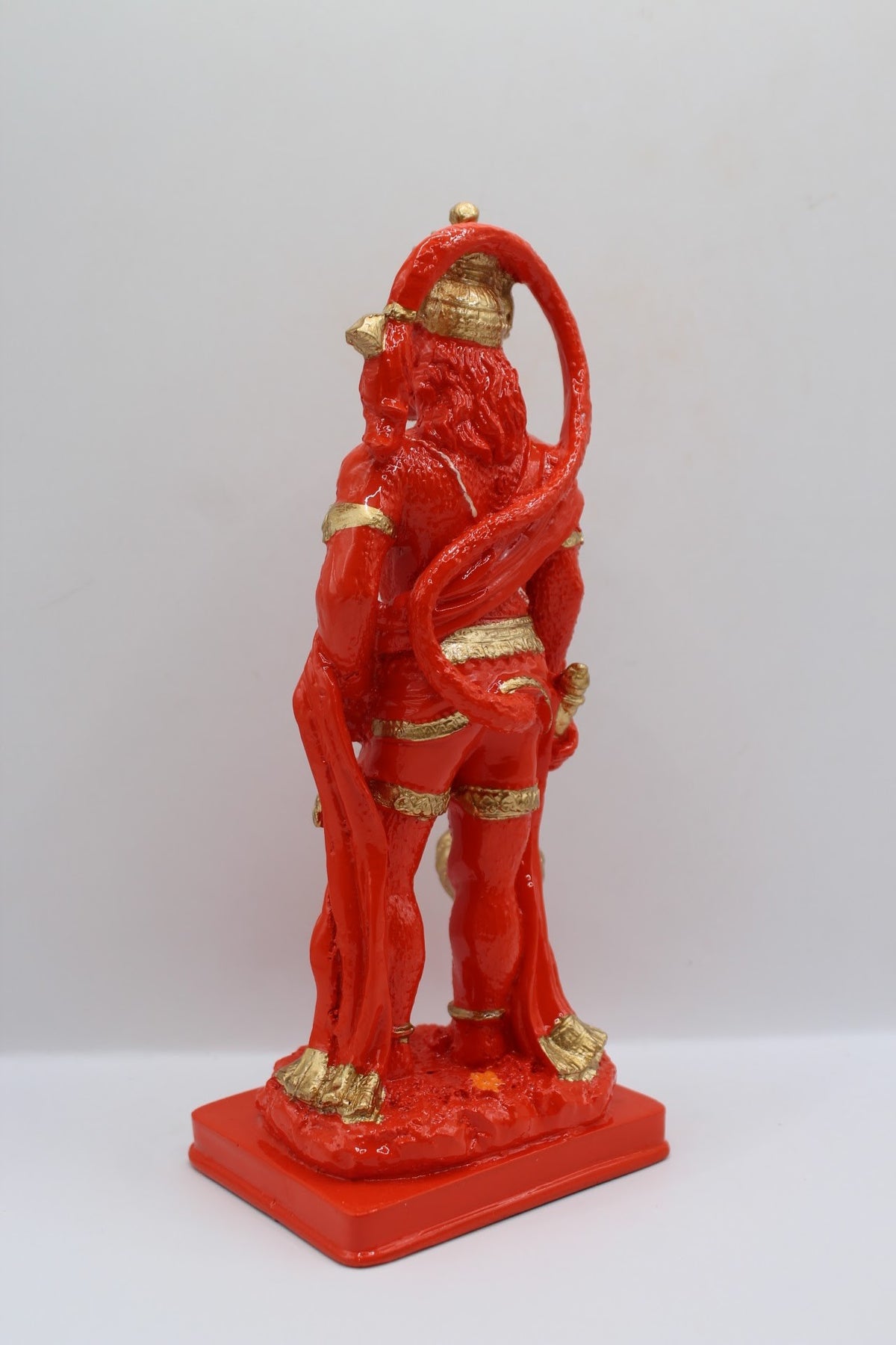 Orange resin Hanuman murti standing with gada, back view