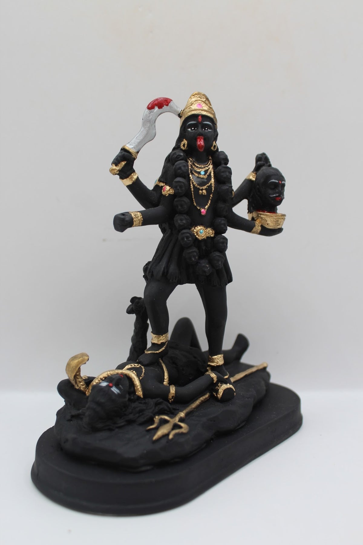 Black and gold resin Kali Mata murti standing on Shiva, left side view