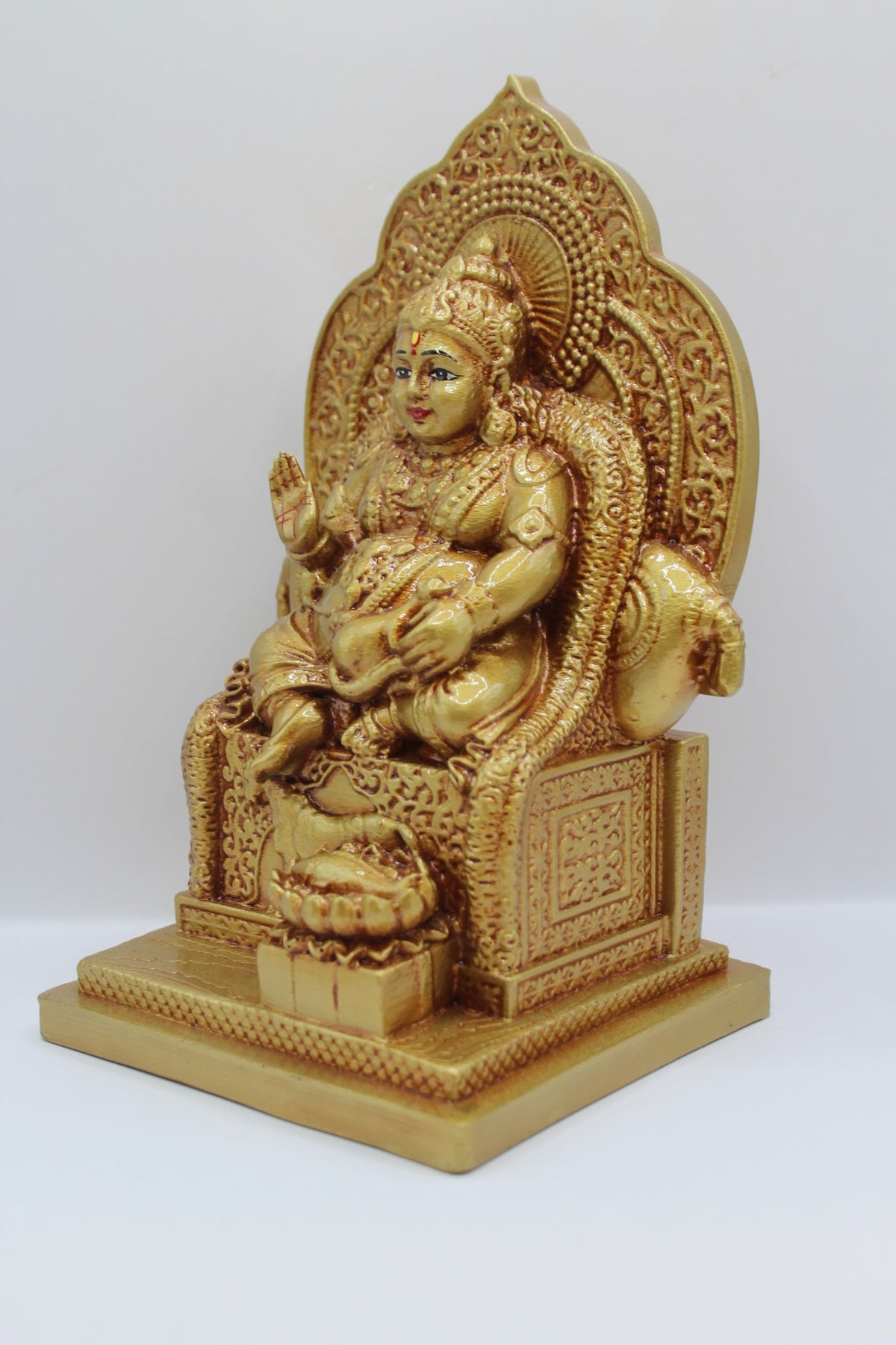Gold resin Kuber murti seated on a throne, right side view