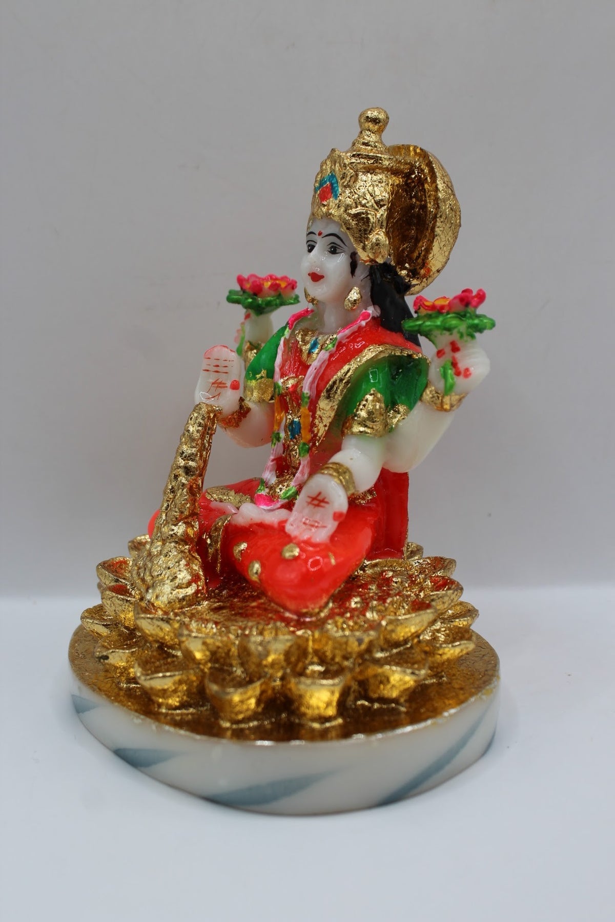Resin Laxmi murti seated on gold coins, white base, right side view