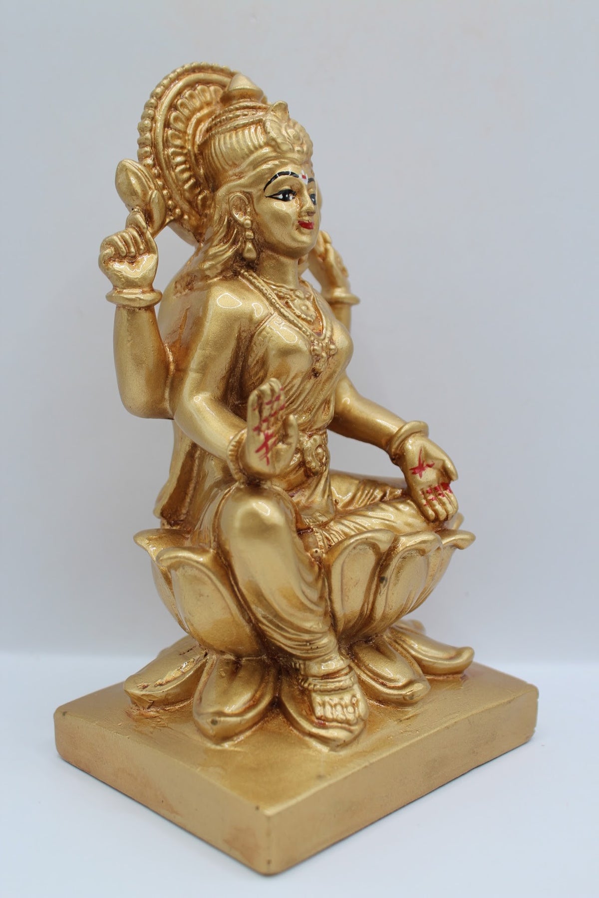 Gold resin Laxmi murti seated on a lotus, left side view
