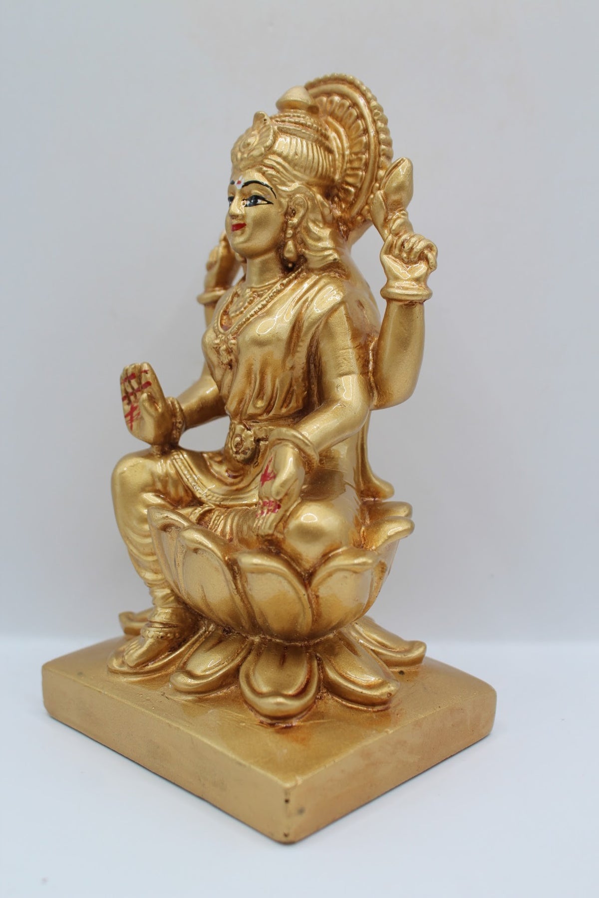 Gold resin Laxmi murti seated on a lotus, right side view