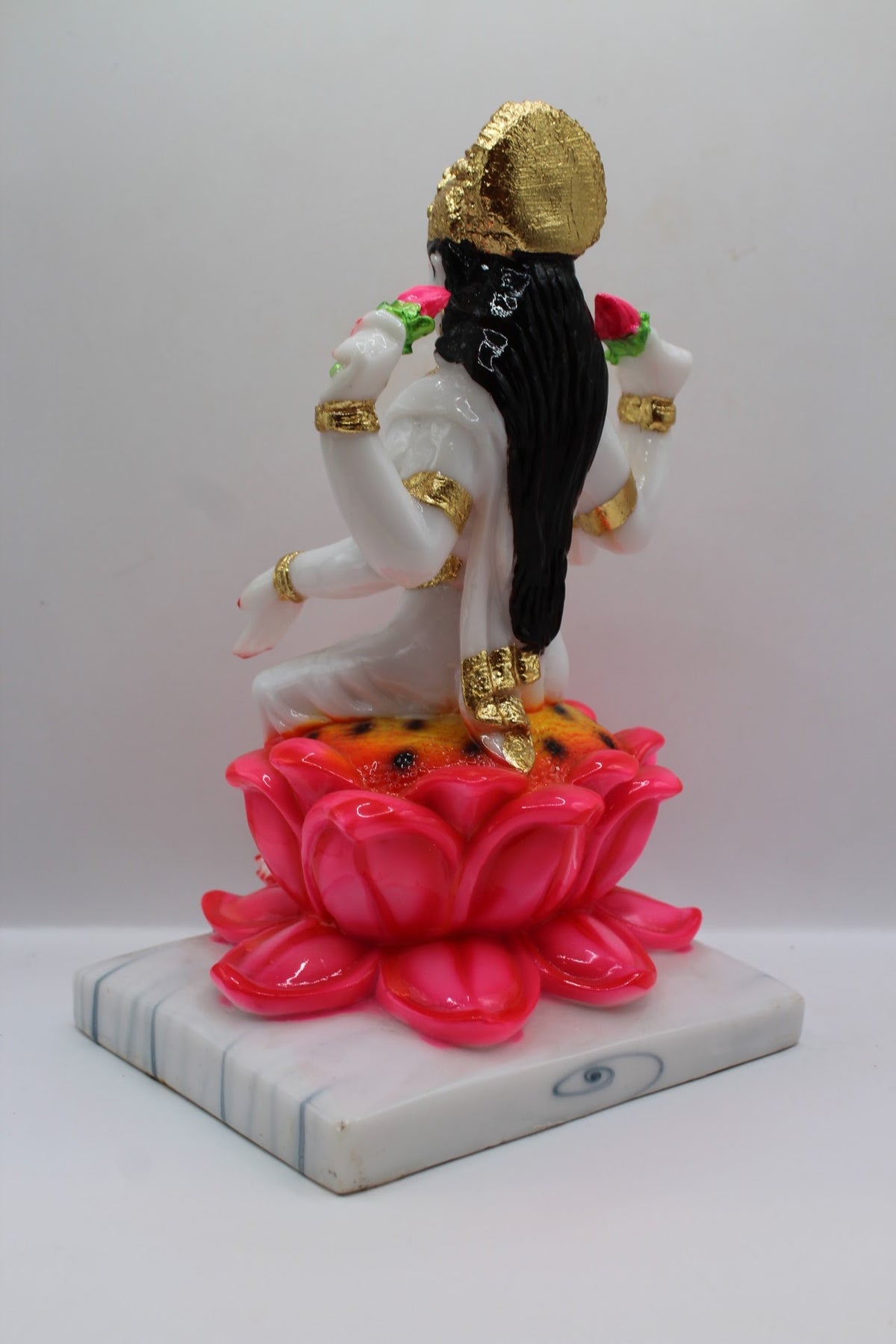 White and gold resin Laxmi murti on a pink lotus, back view
