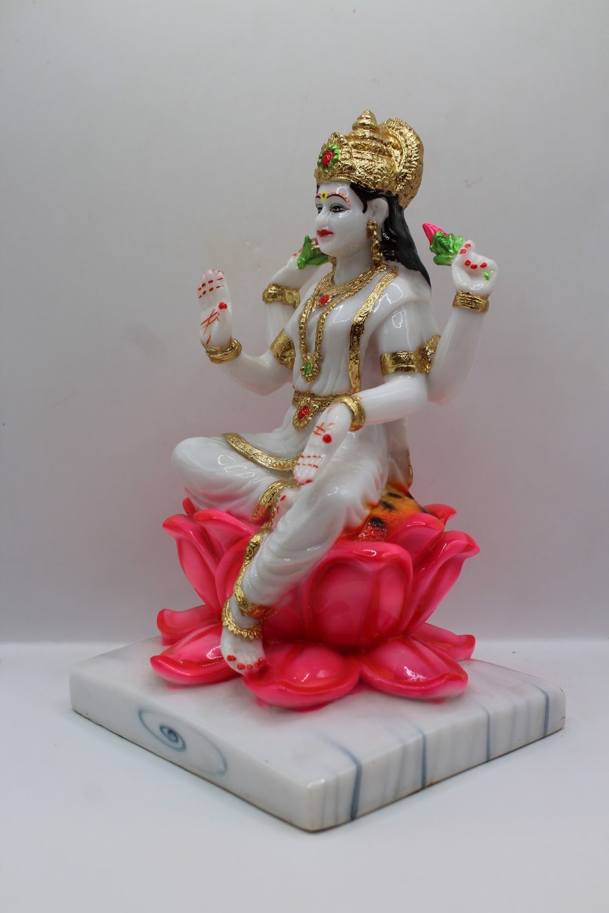 White and gold resin Laxmi murti on a pink lotus, right side view