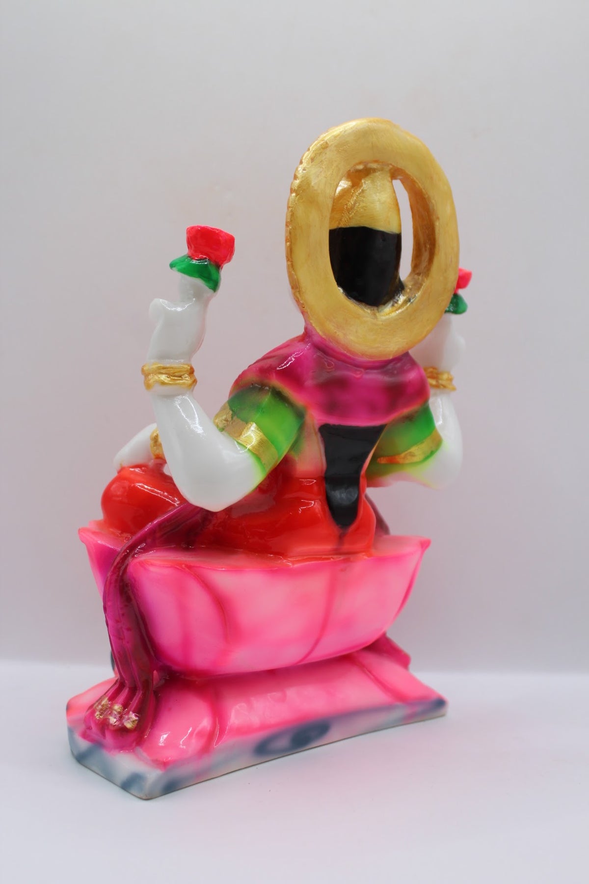Red resin Laxmi murti on a pink lotus, back view