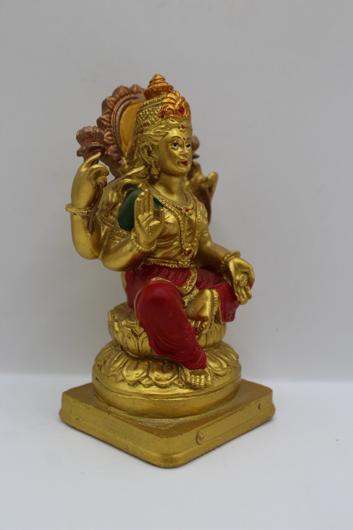 Small gold resin Laxmi murti with red clothes, left side view