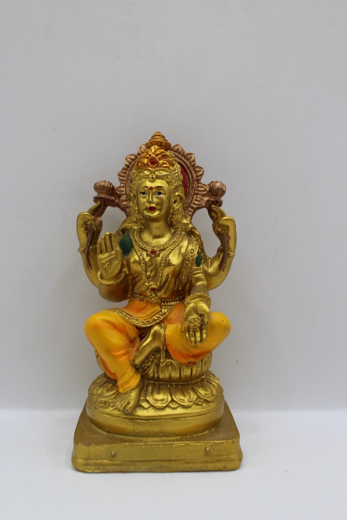 Small gold resin Laxmi murti with yellow clothes, front view