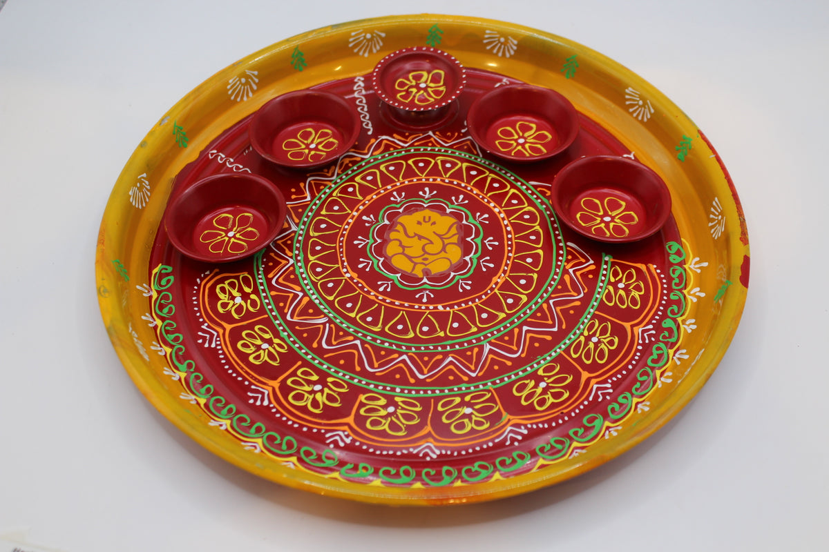 Painted steel pooja thali, yellow and red with katoris – close-up