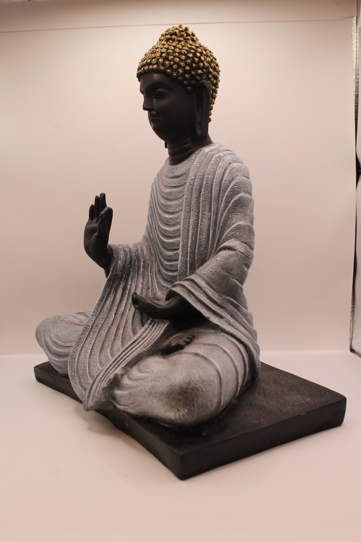 Charcoal grey Buddha statue on base, right side