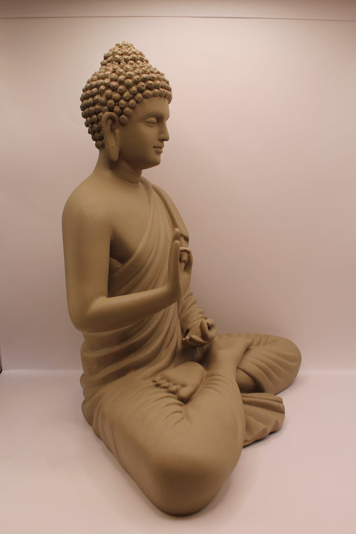 Light greige Buddha statue, left side