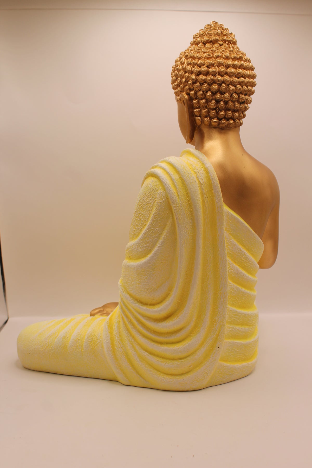 Pastel yellow Buddha statue, back