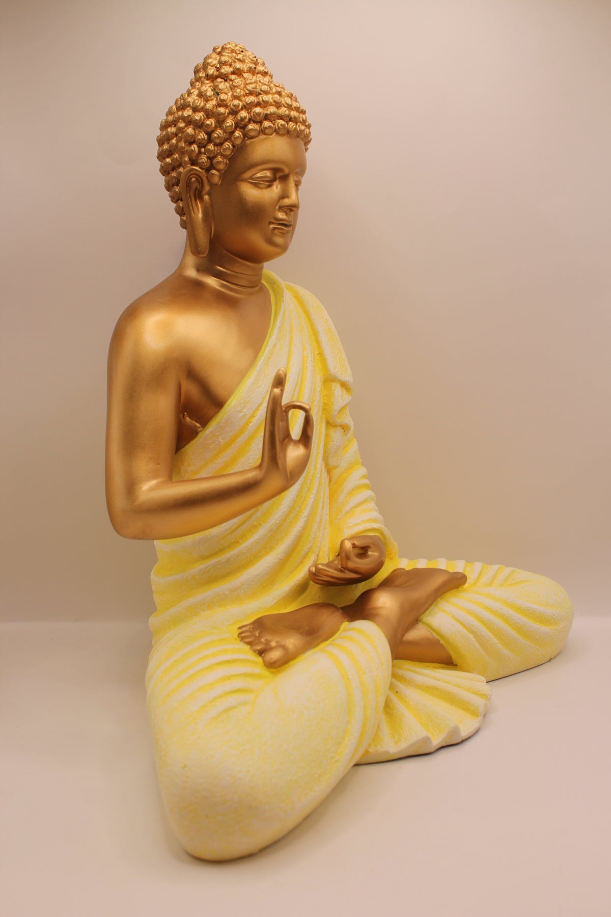 Pastel yellow Buddha statue, left side