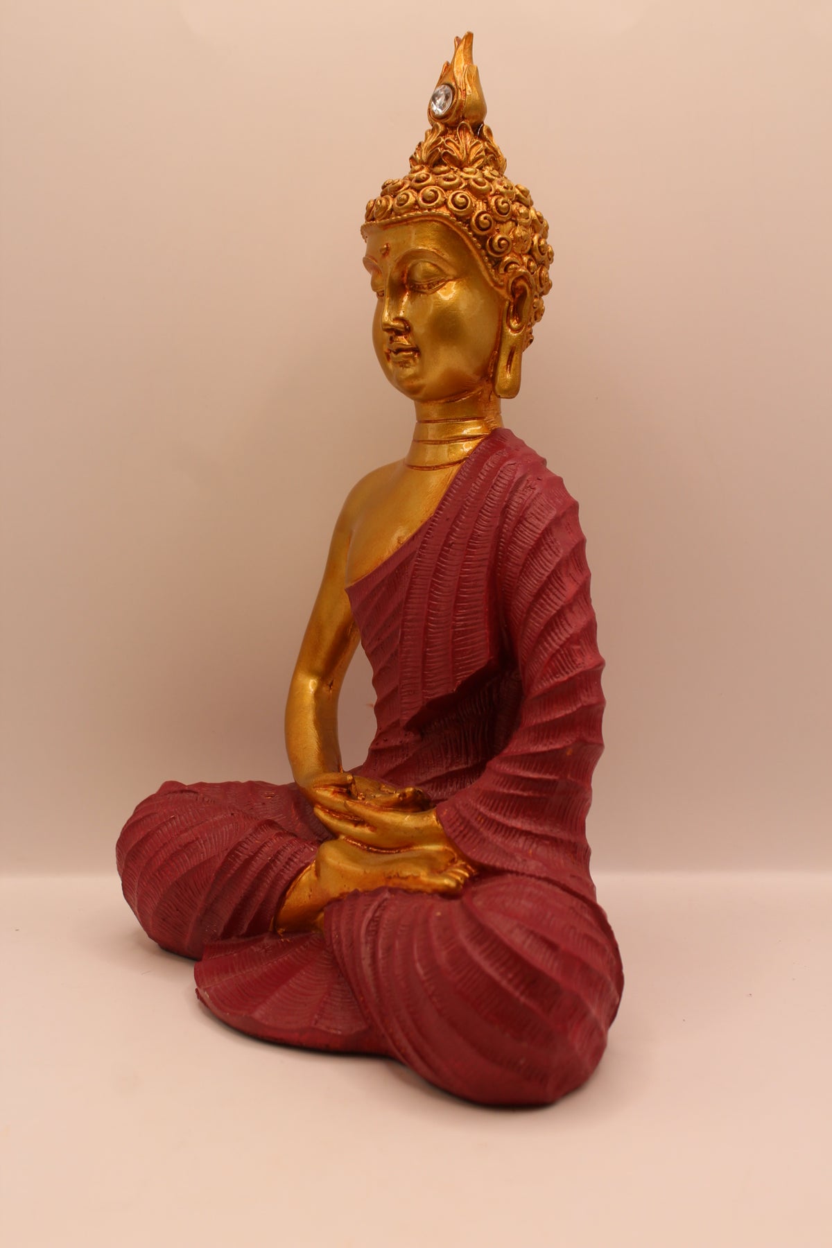 Maroon meditating Buddha statue, right side
