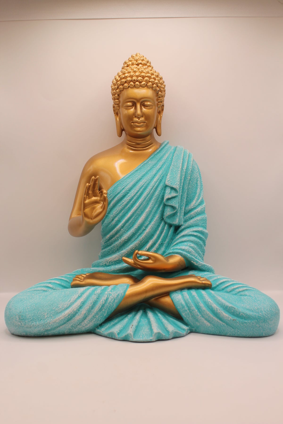 Resin Buddha statue with turquoise robe and gold skin, front