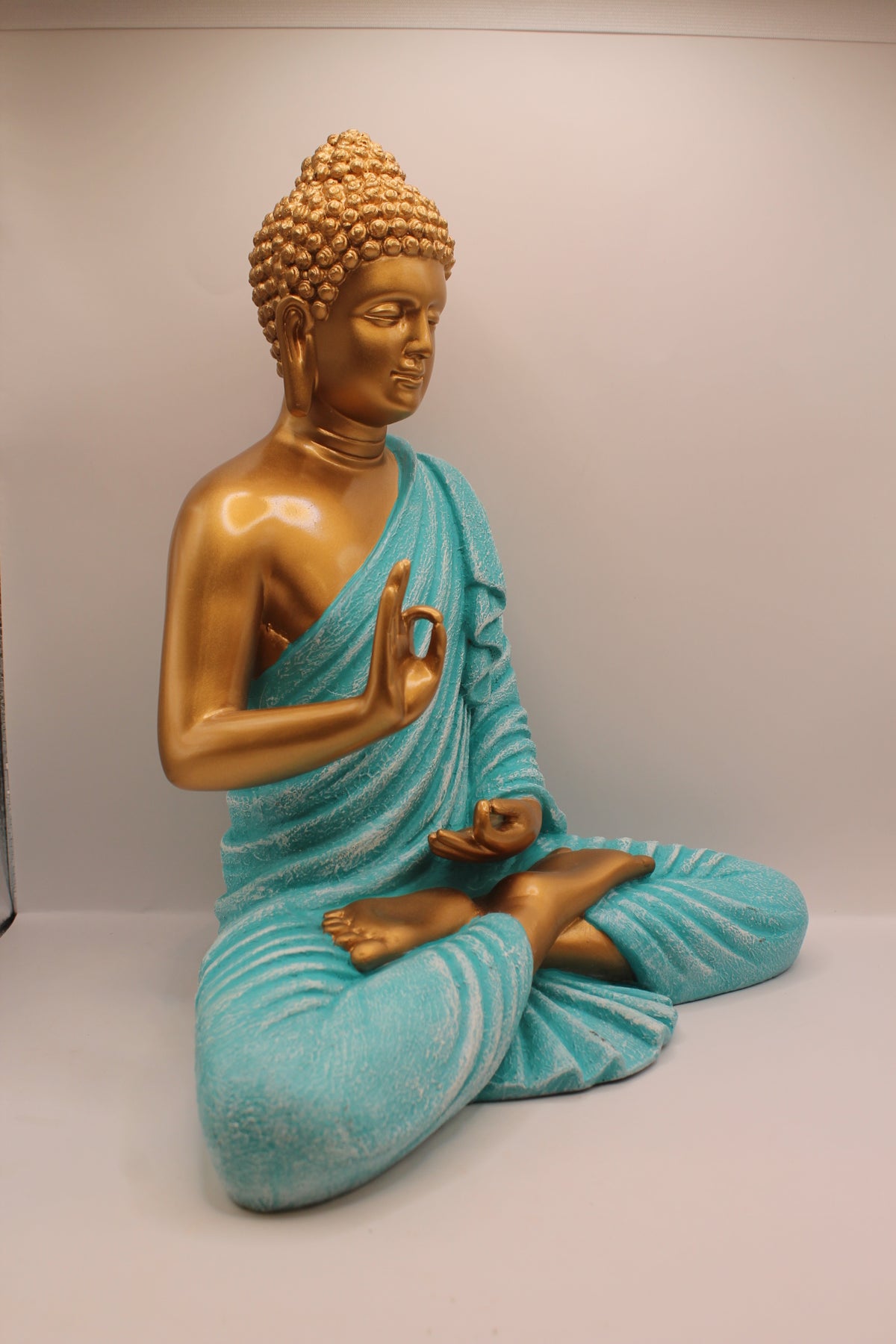 Turquoise and gold Buddha statue, left side