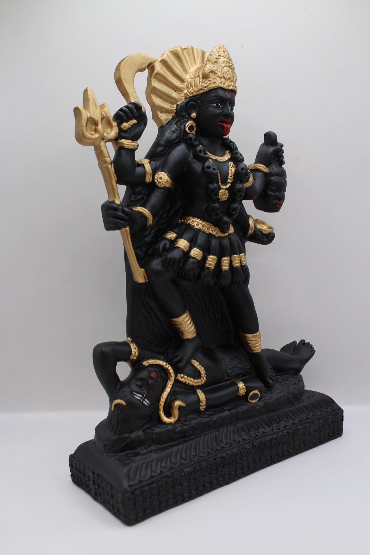 Resin Kali Mata statue, black and gold, standing, left side view