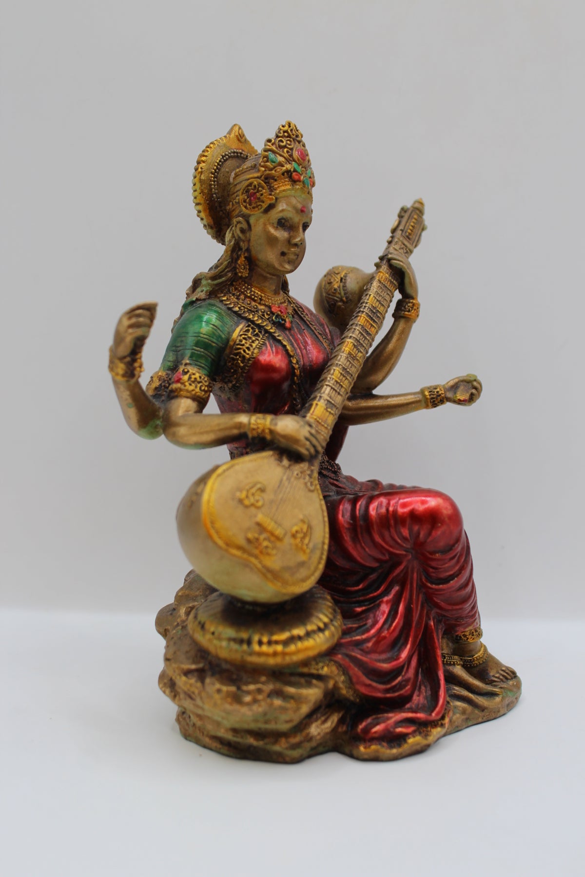 Resin Saraswati statue, playing veena, antique bronze, left side view
