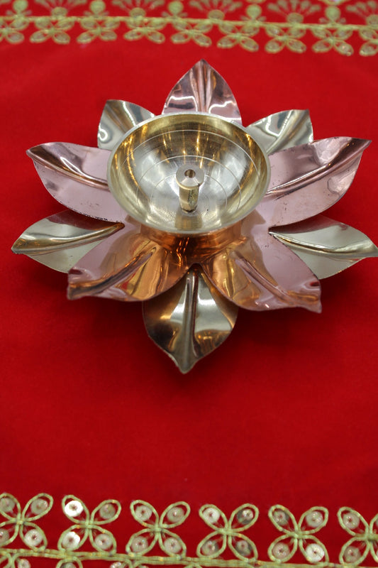 Lotus diya with alternating brass and copper petals around a deep oil well