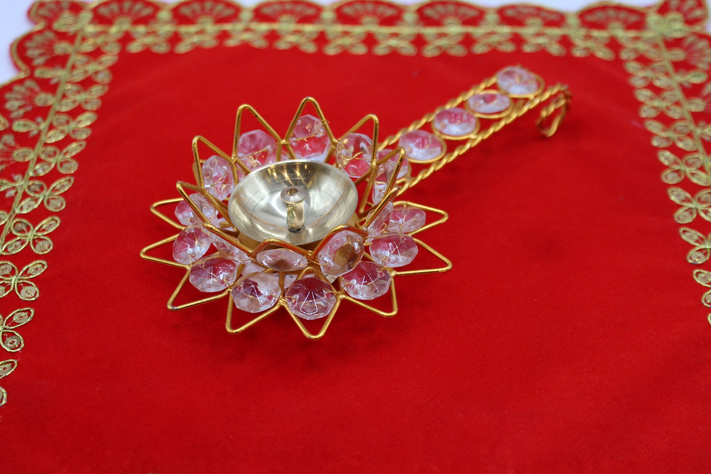 Gold-tone lotus aarti diya set with faceted pink stones and a jewelled handle