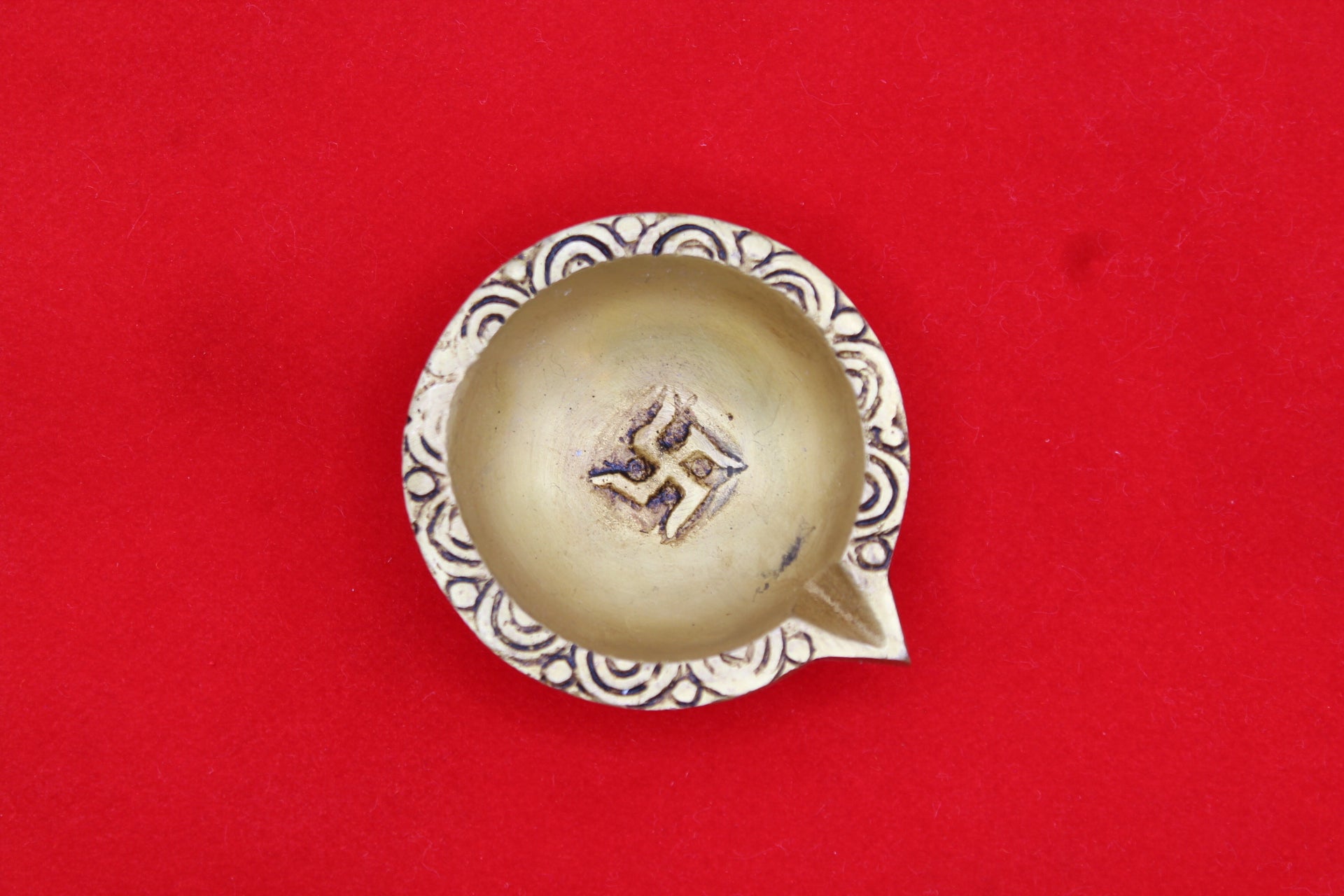 Brass diya, scrollwork band round the rim