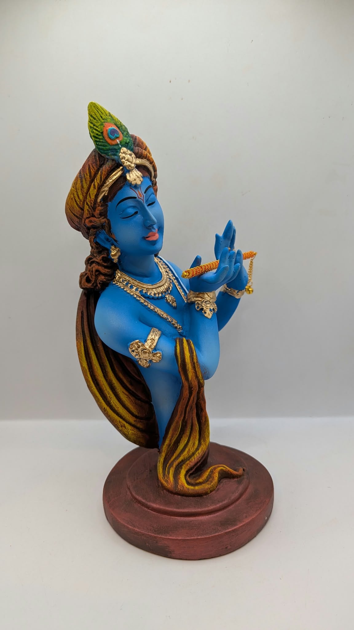 Blue Lord Krishna bust statue with flute, three-quarter view