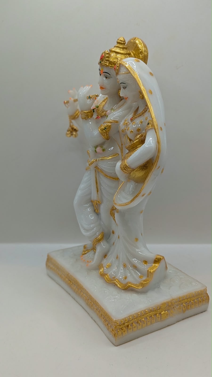 White and gold Radha Krishna statue with flute, other side view
