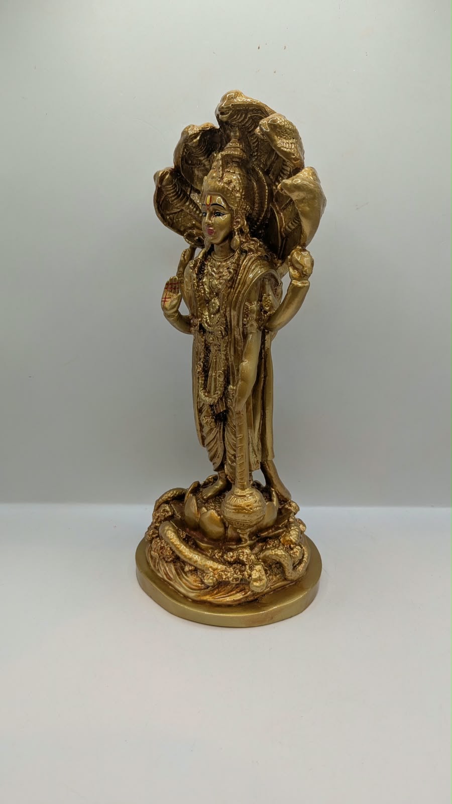 Gold Lord Vishnu statue with snake hood, back view