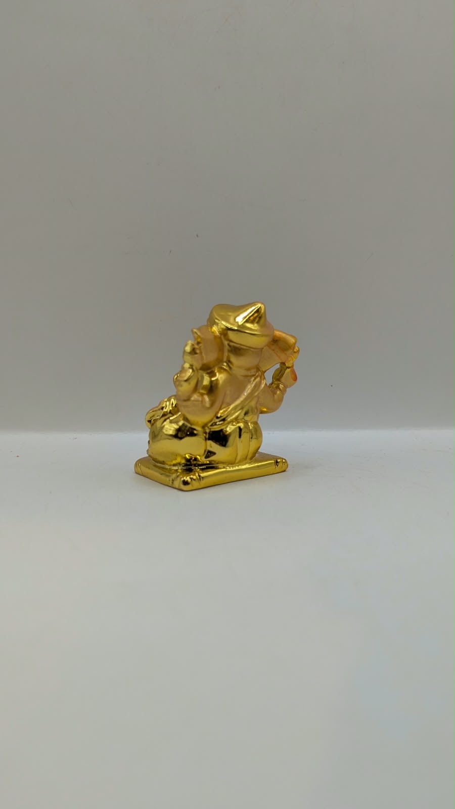 Small gold Ganesh statue, back view