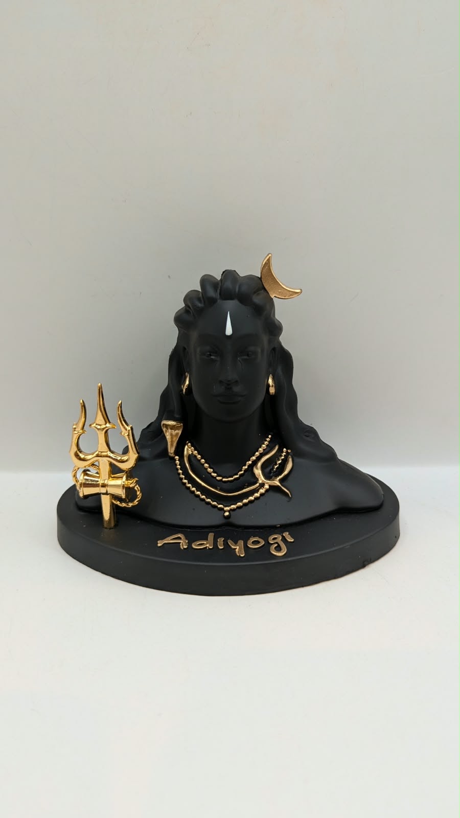 Black Adiyogi Shiva statue with gold trishul, front view