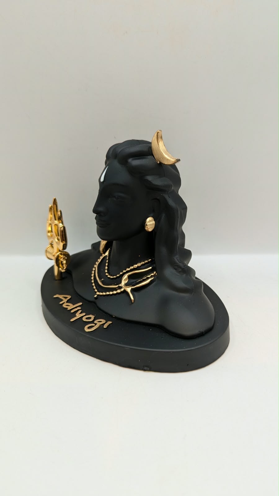 Black Adiyogi Shiva statue with gold trishul, other side view