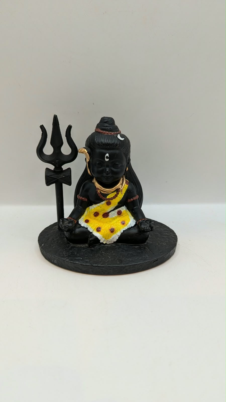 Small black sitting Shiva statue with trishul, front view