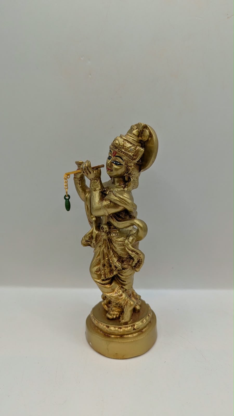 Gold Lord Krishna statue with flute, other side view