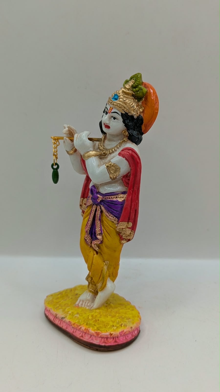 Colourful Lord Krishna statue with flute, other side view