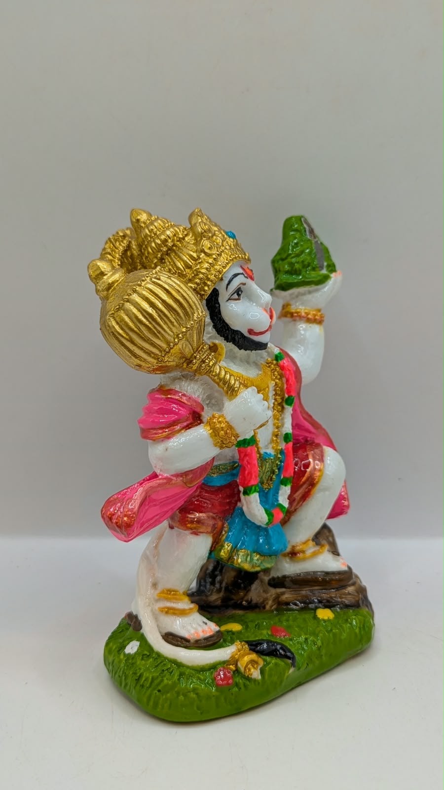 Colourful Hanuman statue with mountain and mace, side view