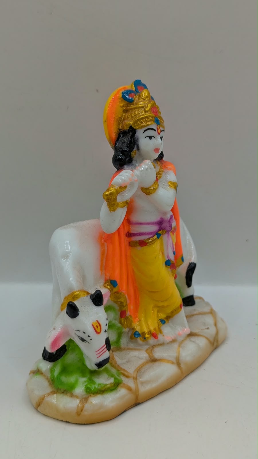 Lord Krishna statue standing with cow, side view