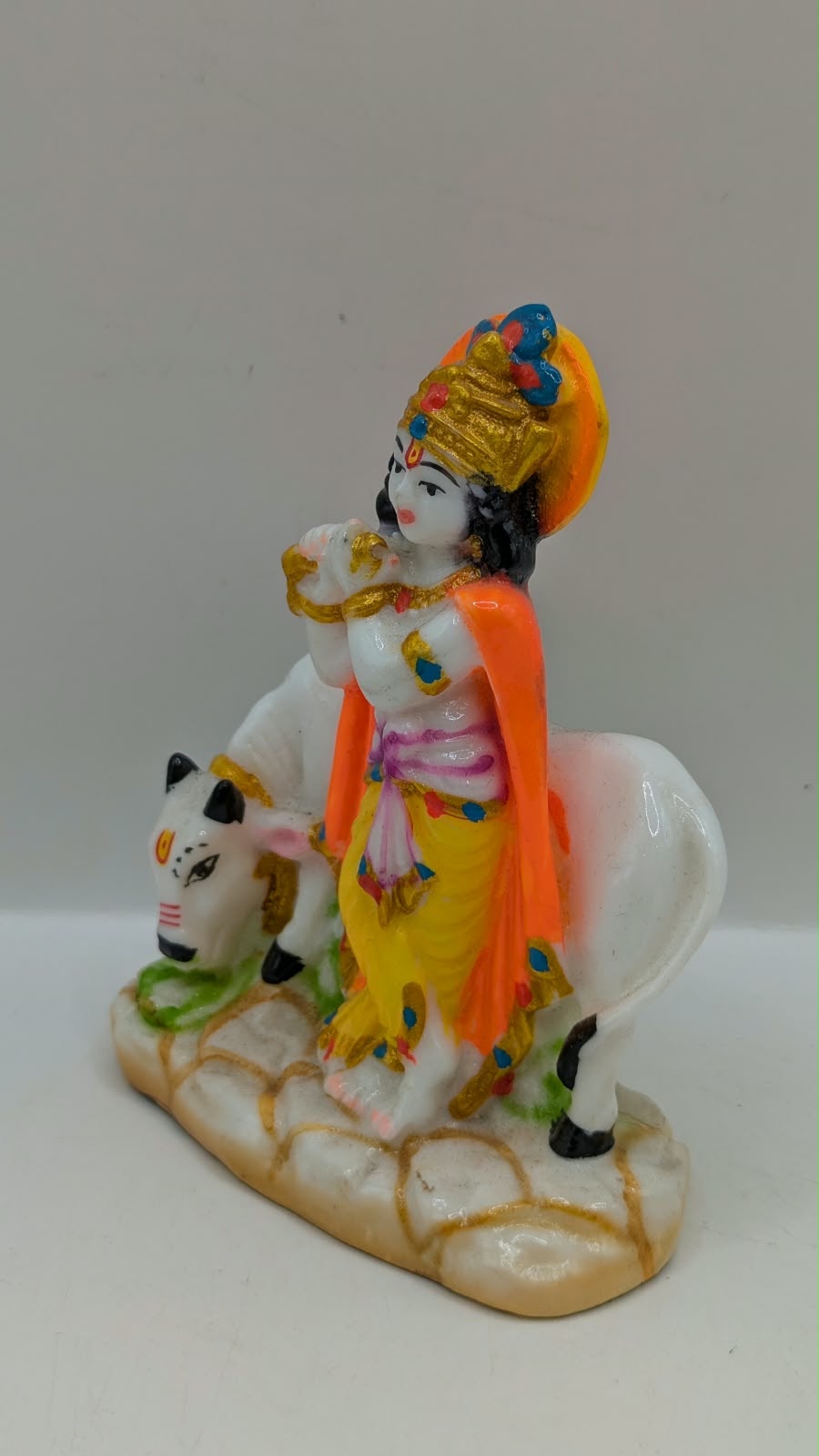 Lord Krishna statue standing with cow, other side view