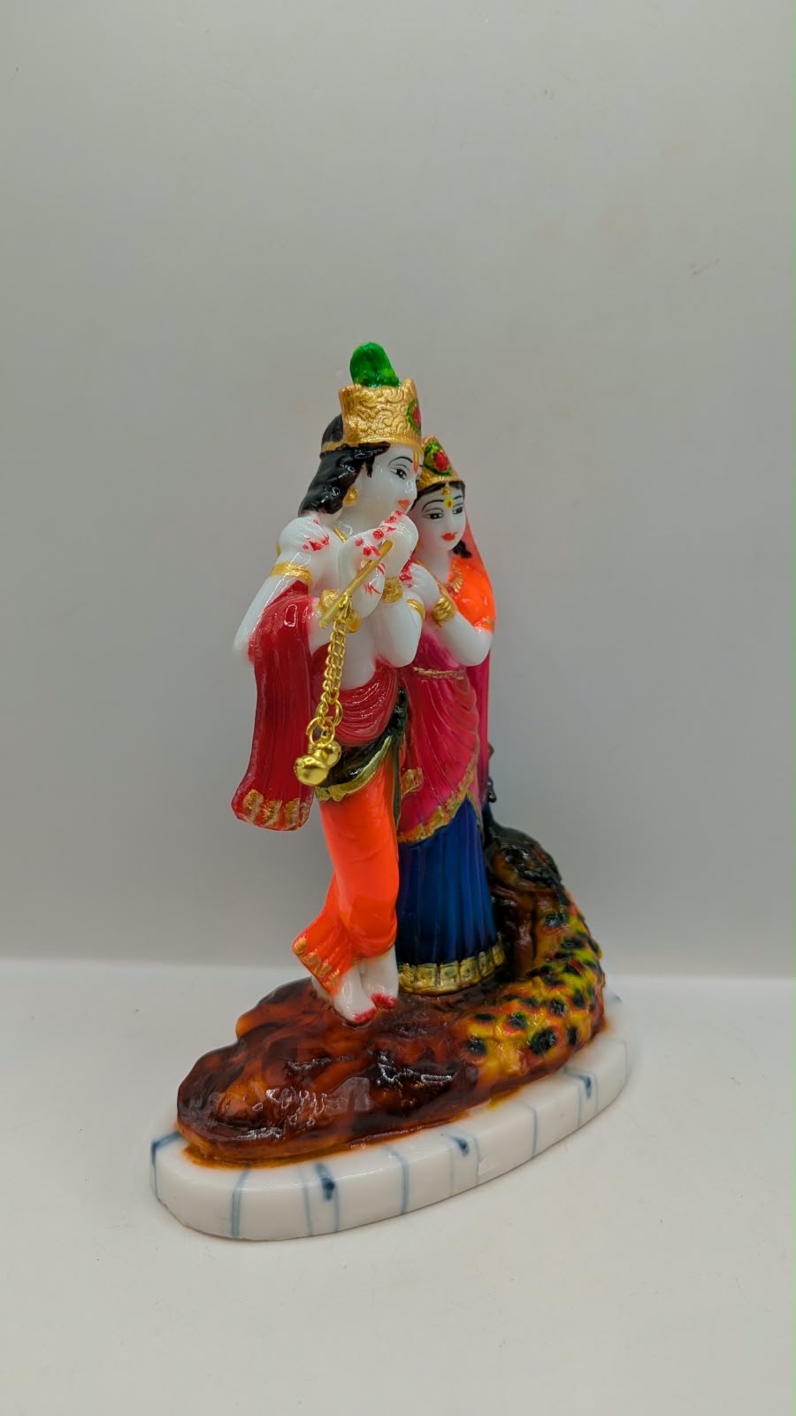 Colourful Radha Krishna statue with peacock, side view