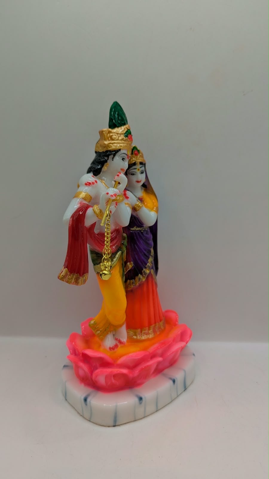 Colourful Radha Krishna statue on pink lotus, side view