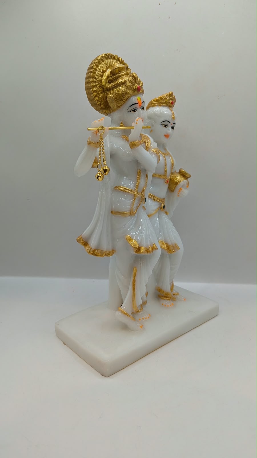 White and gold Radha Krishna statue with halo, side view
