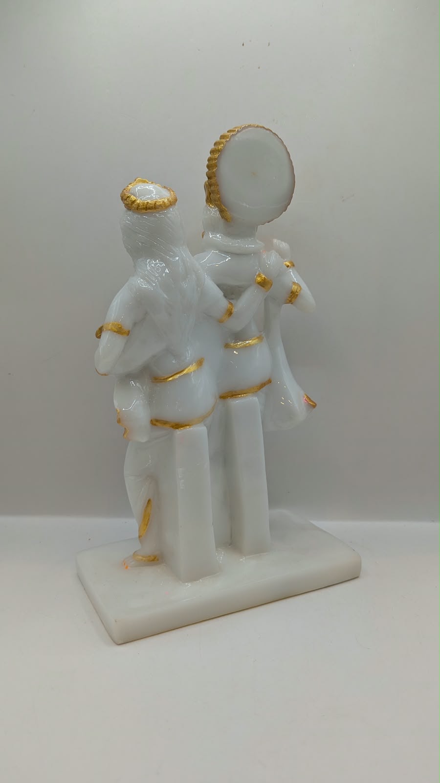 White and gold Radha Krishna statue with halo, back view