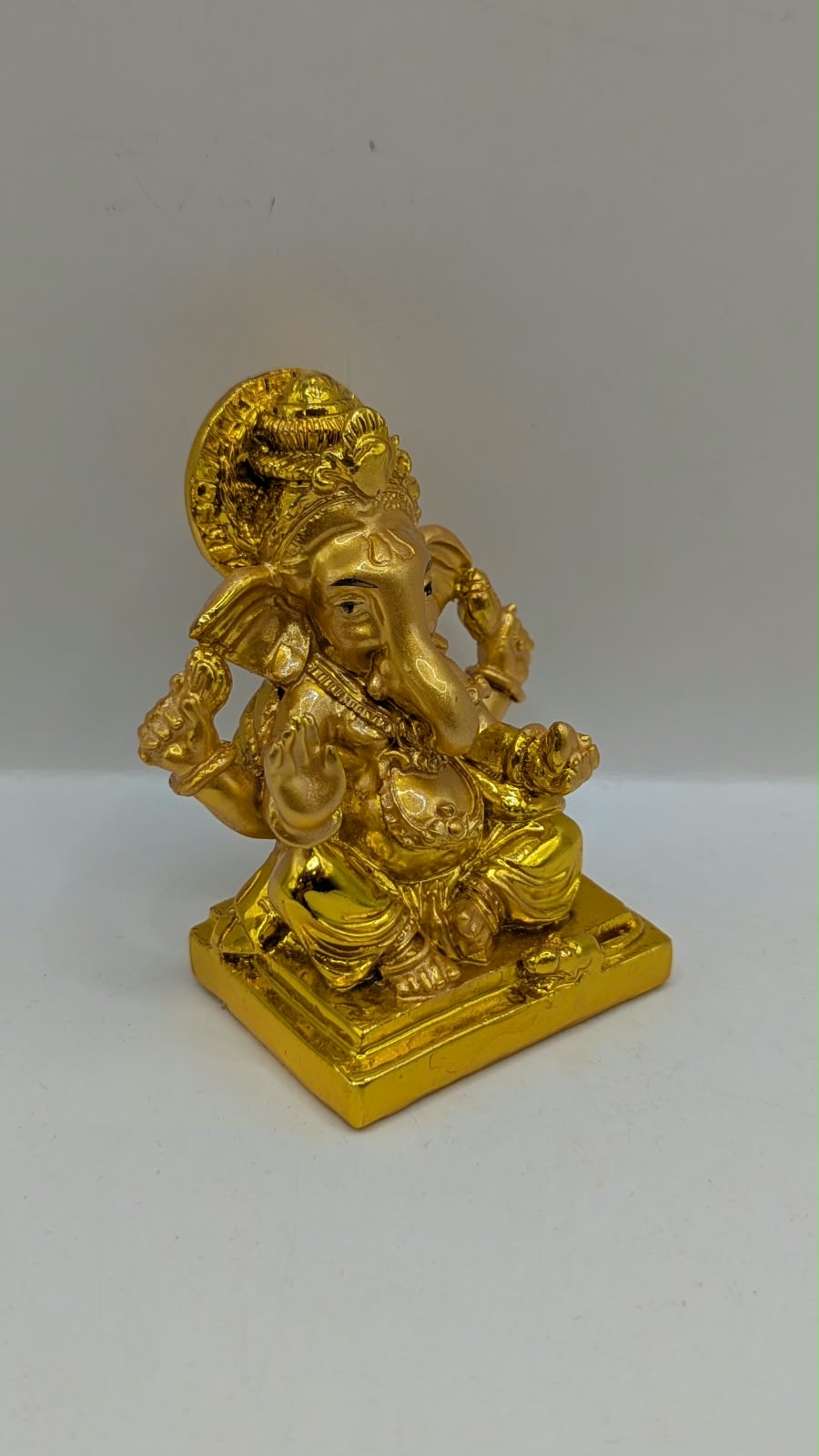 Gold Ganesh statue with round halo, side view