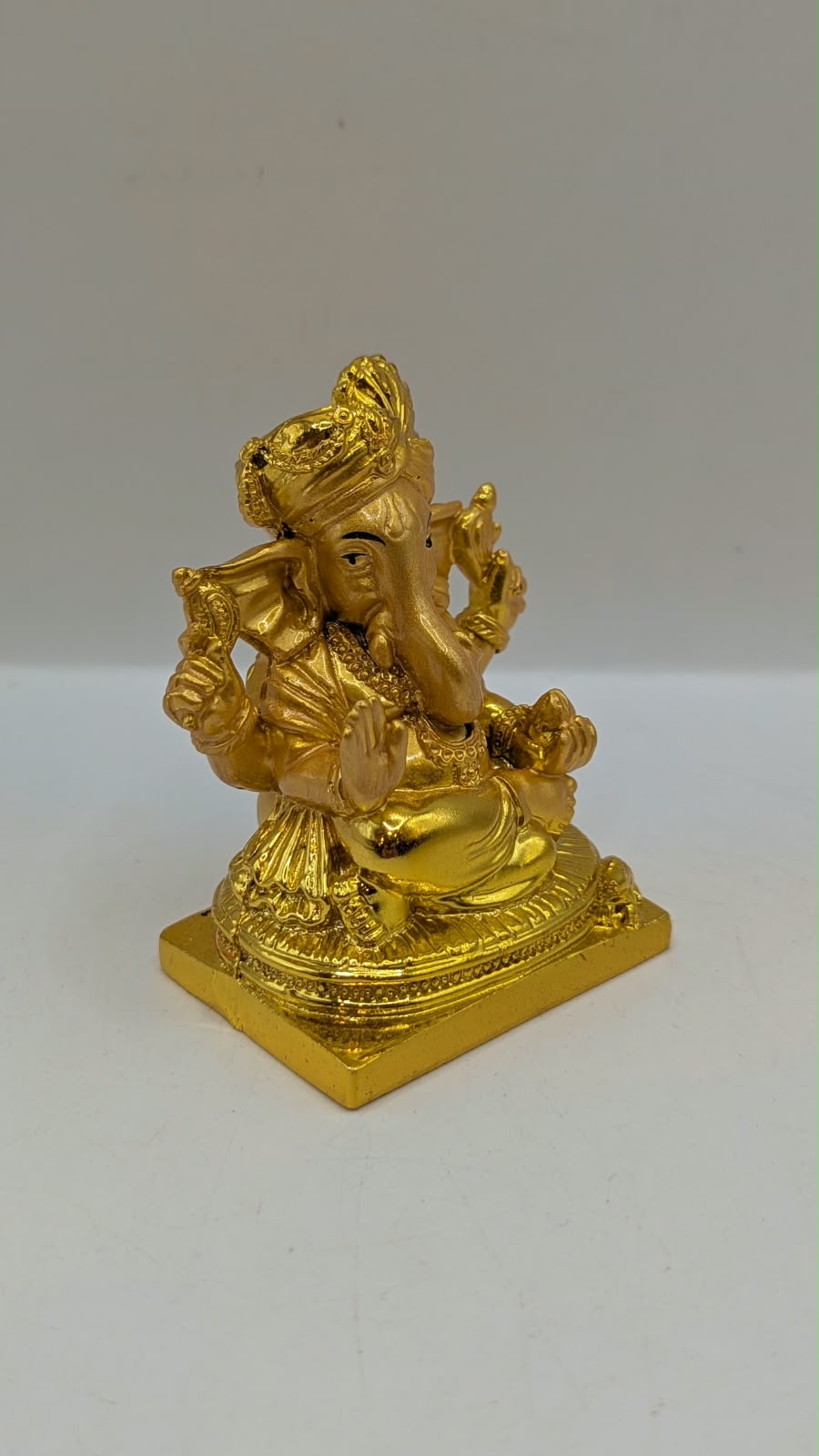 Gold Ganesh statue wearing a turban, side view
