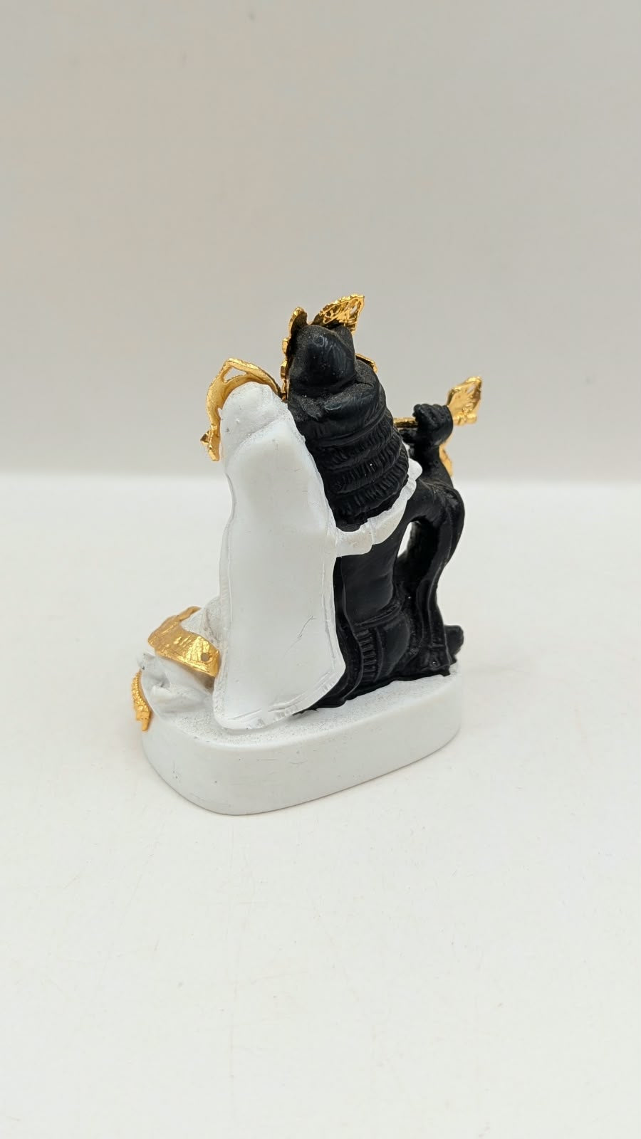 Black and white Radha Krishna statue with gold, back view