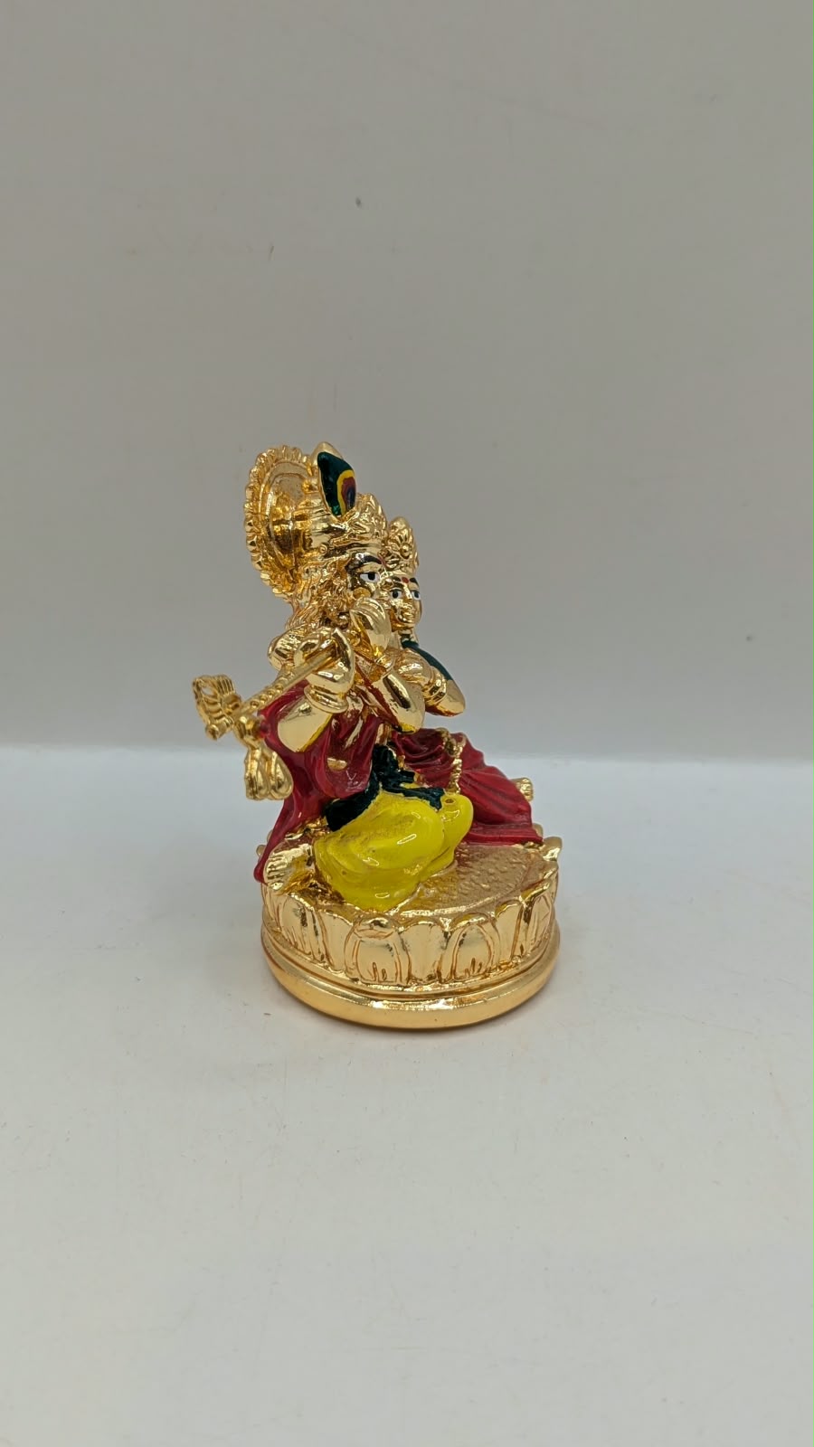 Gold Radha Krishna statue on a lotus base, side view