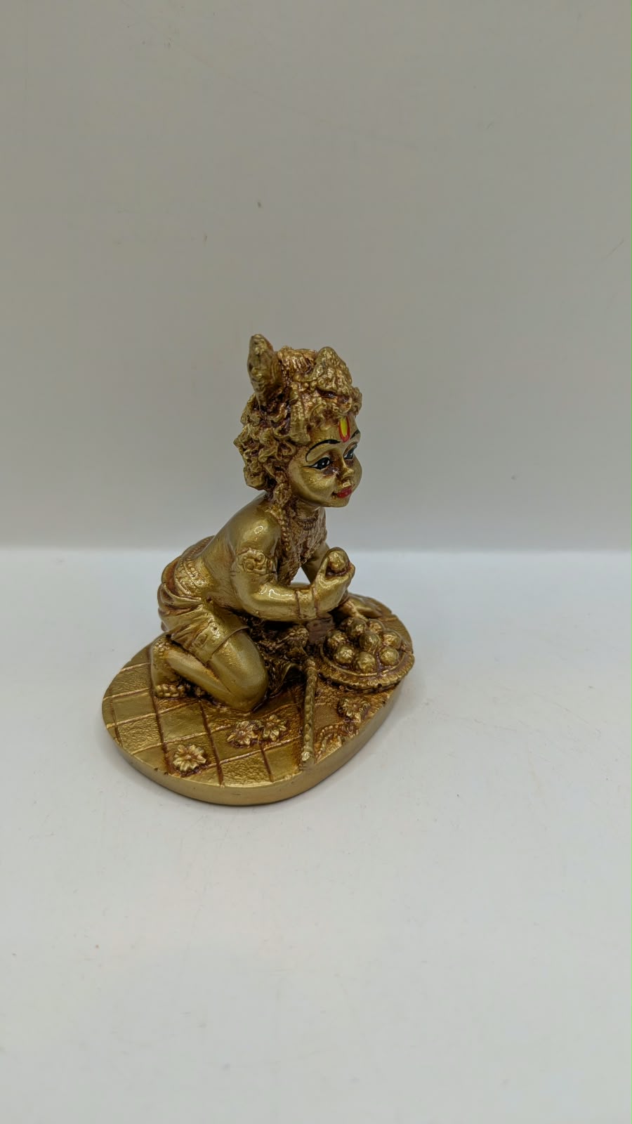 Gold crawling baby Krishna statue, side view