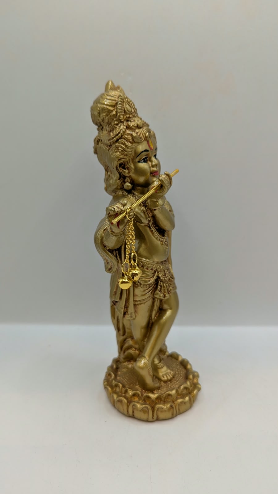 Gold standing Krishna statue with flute, side view