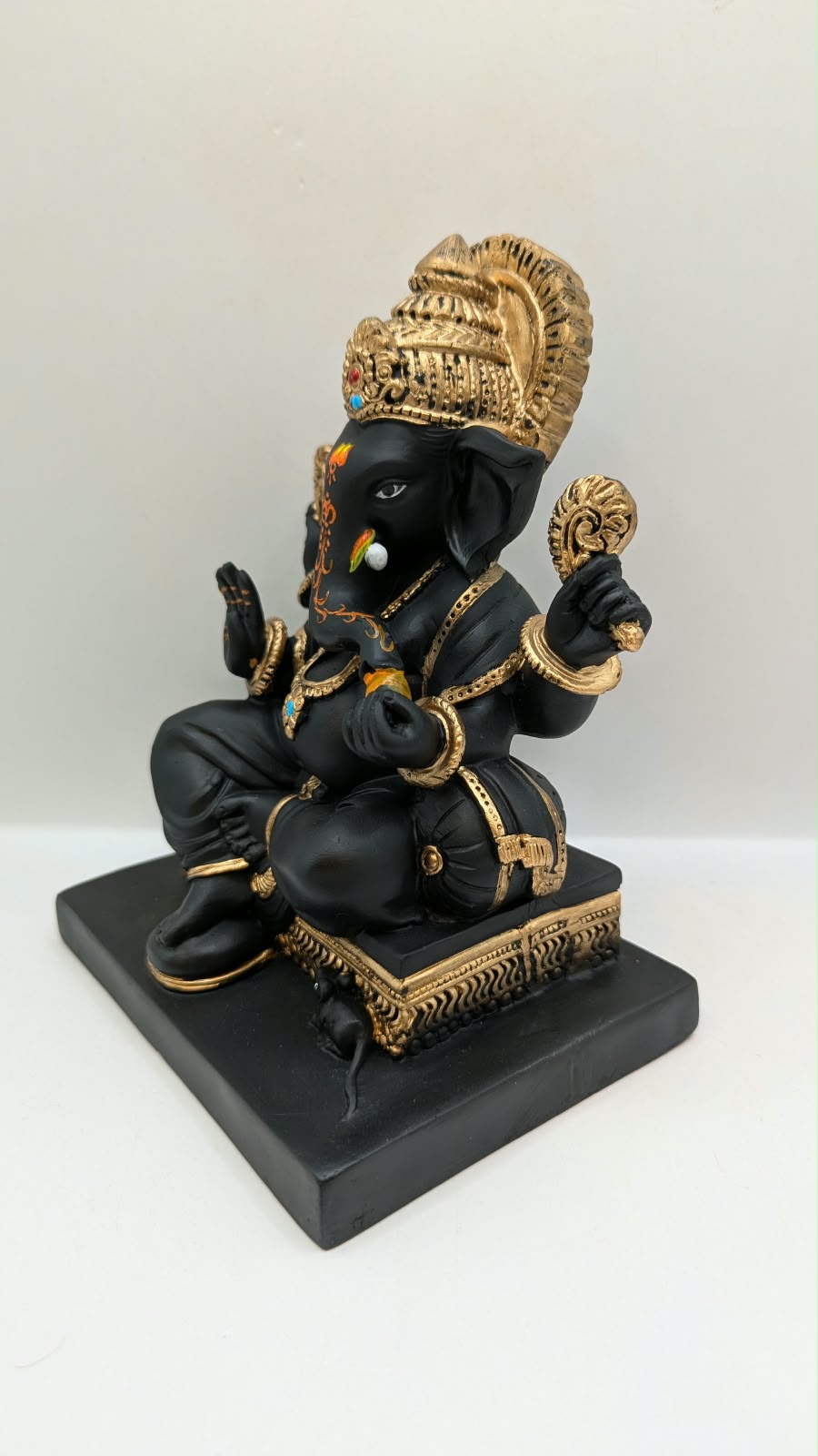 Black and gold Ganesh statue on square base, other side view
