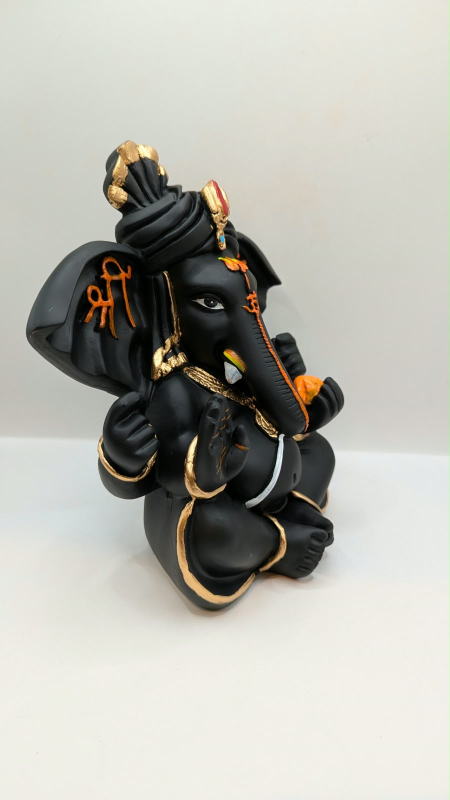 Black Ganesh statue with Shri on ears, side view